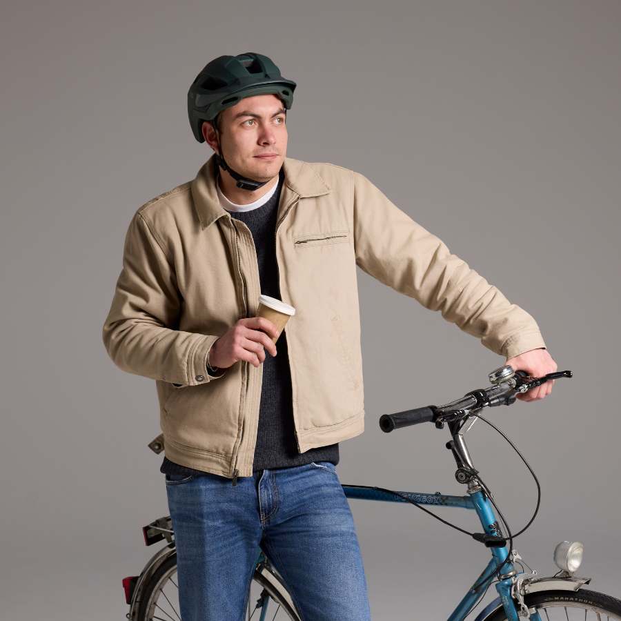 Mann mit beigem KED Embrace Urban UF-1 Helm neben seinem Fahrrad