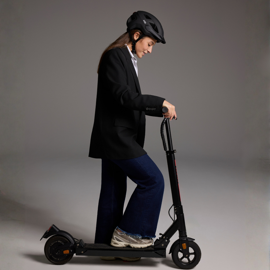 Mann im Anzug auf E-Scooter mit hellem KED Embrace Urban UF-1 Helm