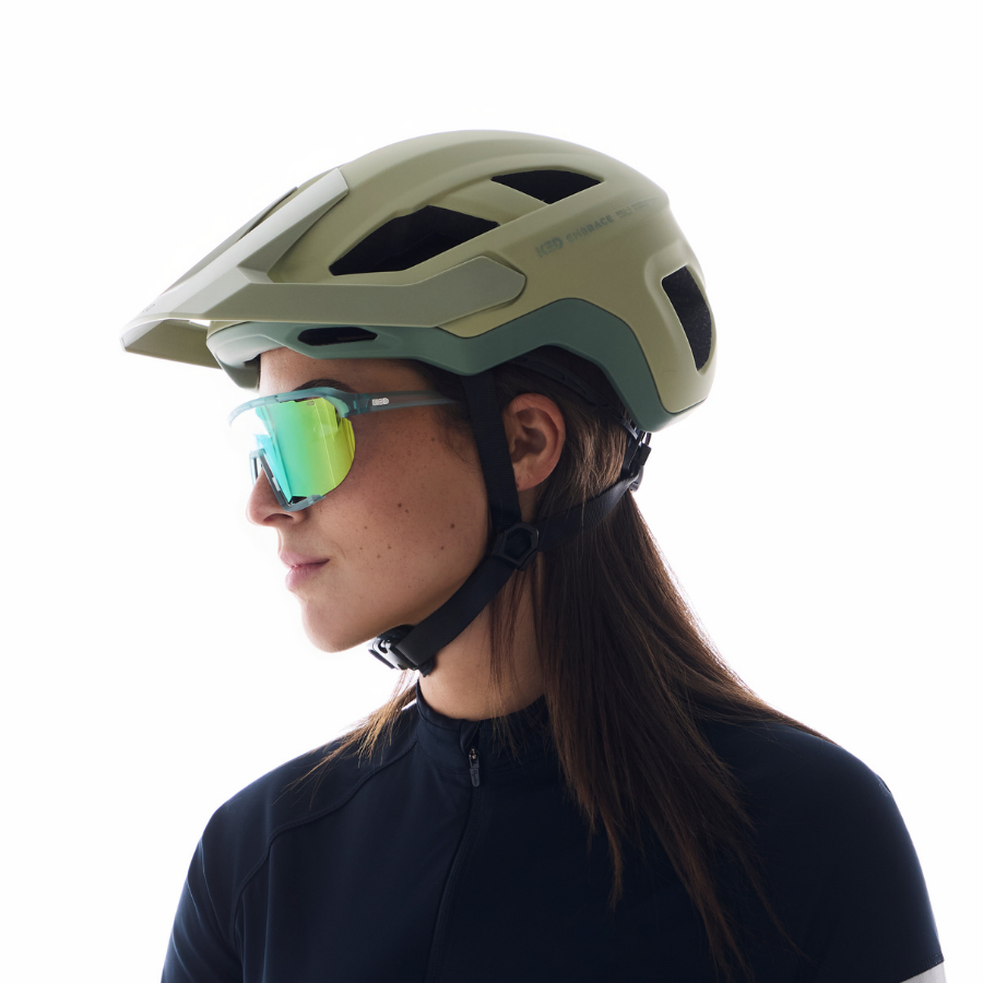 Frau im Profil mit olivgrünem KED Embrace MU-1 Helm und Sonnenbrille
